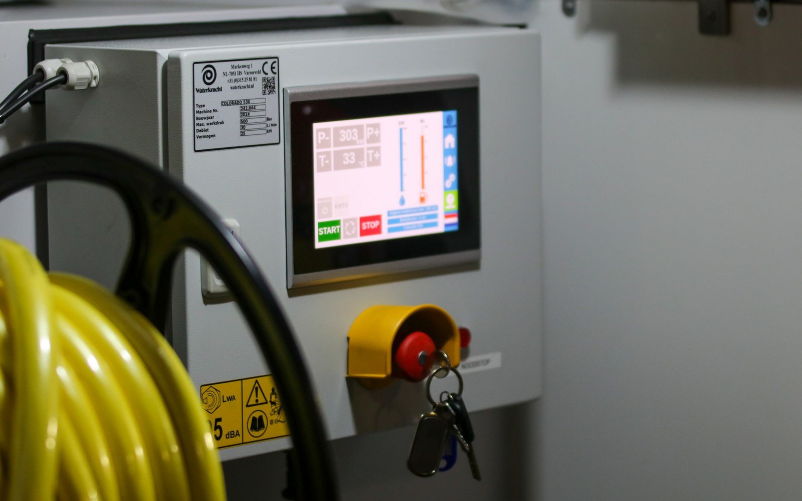 Brewhouse control panel with the batch monitoring screen lit, an adult operator standing at the console