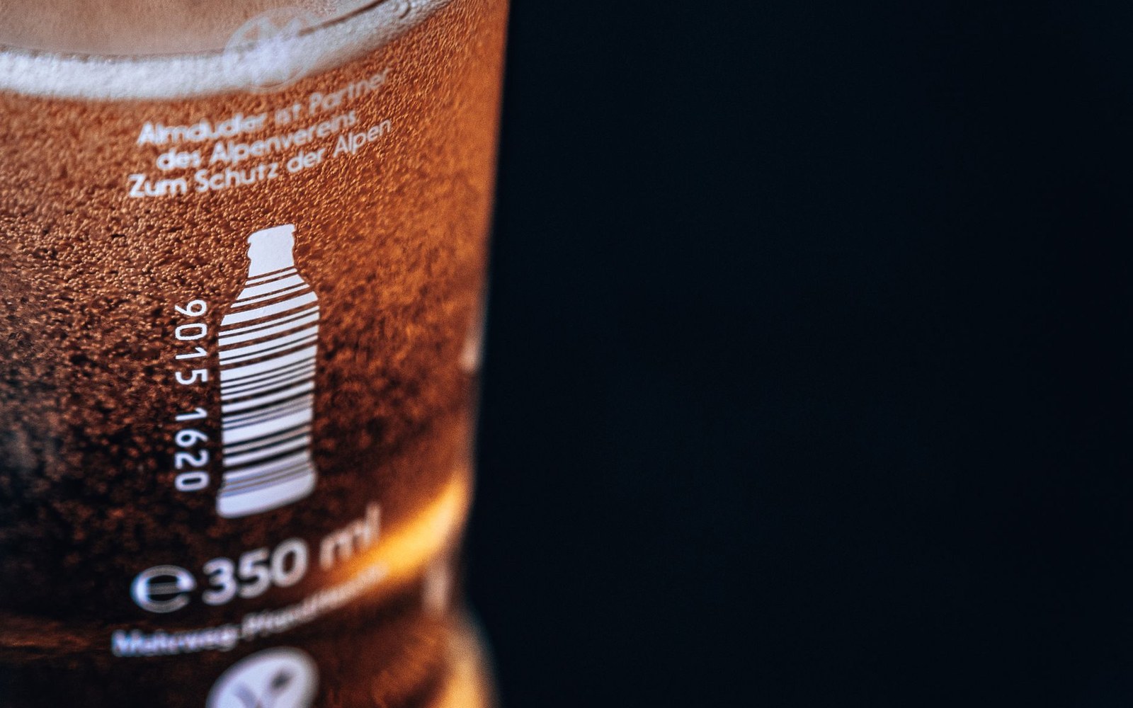 Close-up of a beer glass showing a bottle deposit symbol and 350 ml volume label
